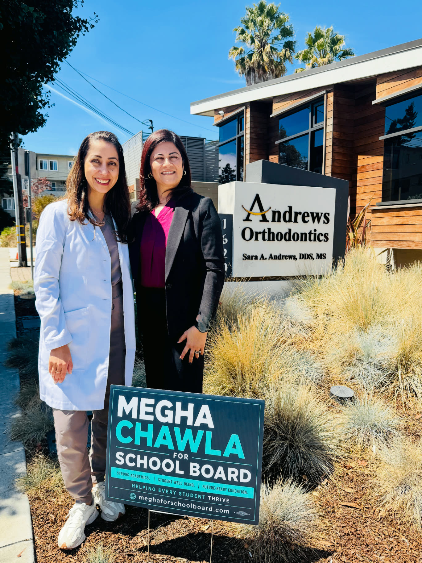 Megha Chawla with a local supporter beside a campaign sign in San Carlos